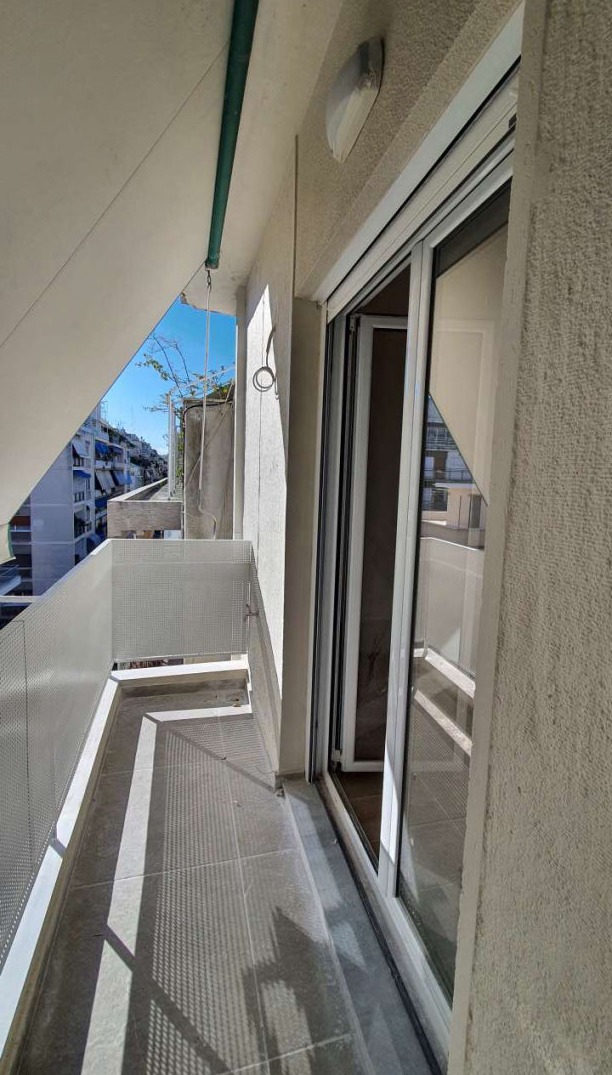 φωτογραφία καθιστικού μετά την ανακαίνιση. Το καθιστικό, το χωλ και η κουζίνα ενοποιήθηκαν