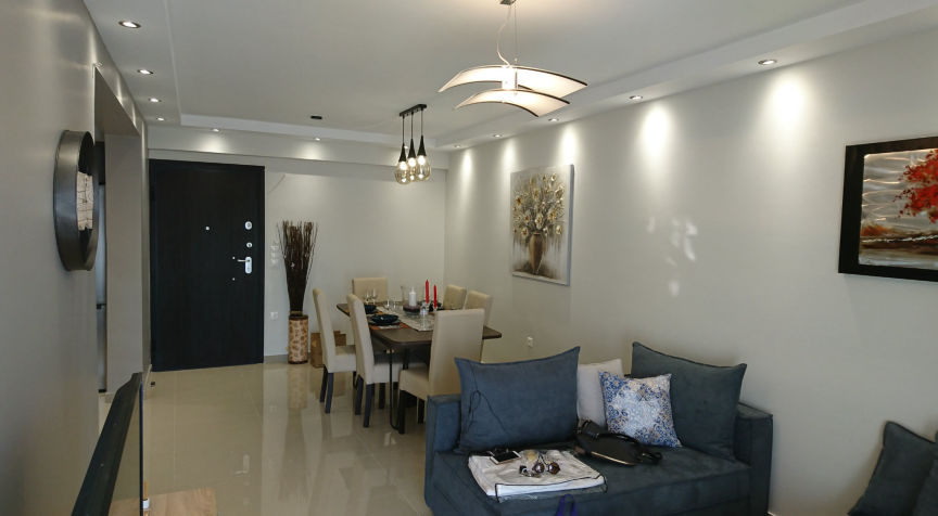 φωτογραφία καθιστικού μετά την ανακαίνιση. Το καθιστικό, το χωλ και η κουζίνα ενοποιήθηκαν